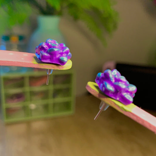 Two colorful hair clips on a wooden surface with a blurred background