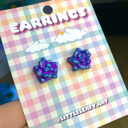 Pair of purple flower-shaped earrings on a checkered card with 'LITTLELEAFY ART' branding.