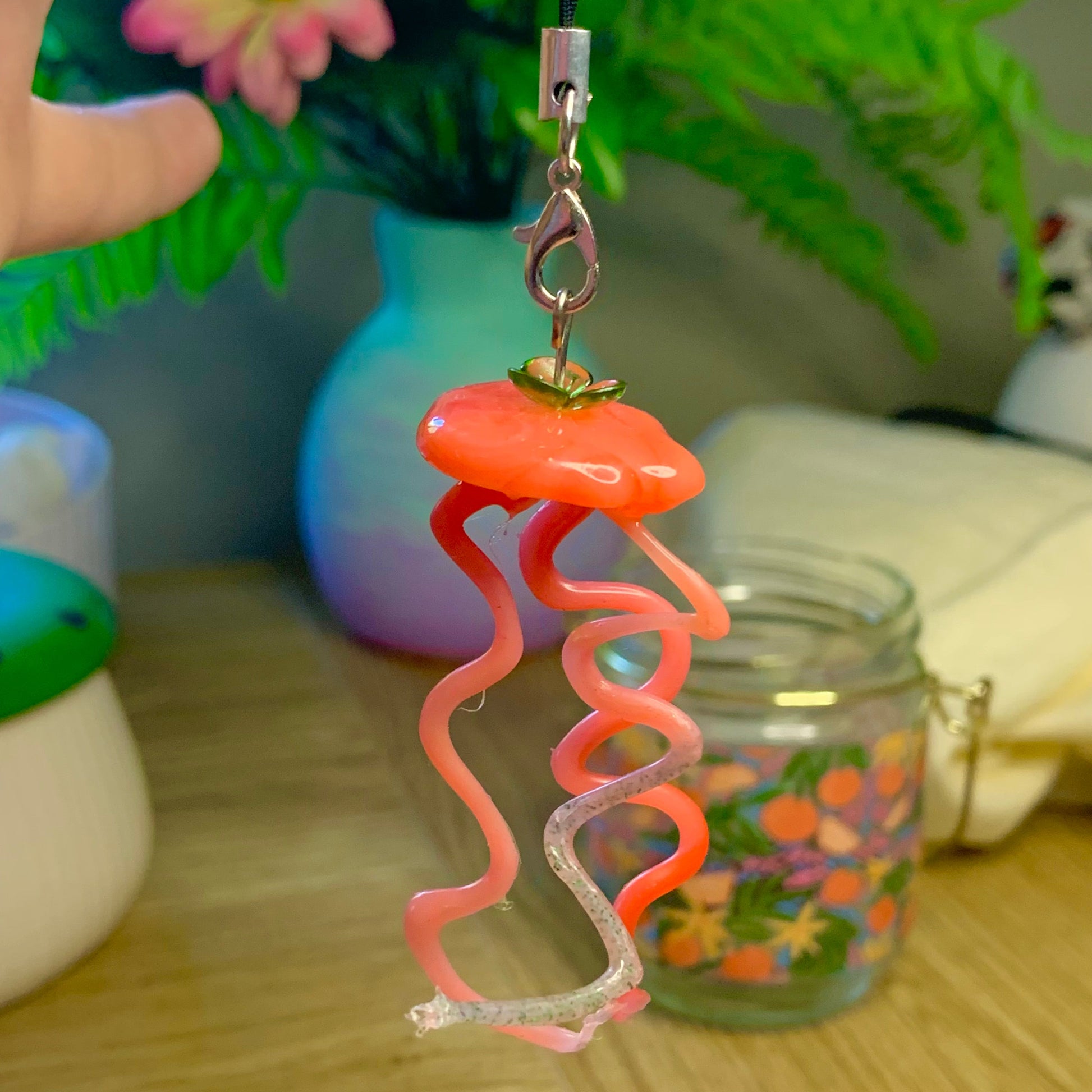 Pink spiral charm on a wooden surface with a blurred background