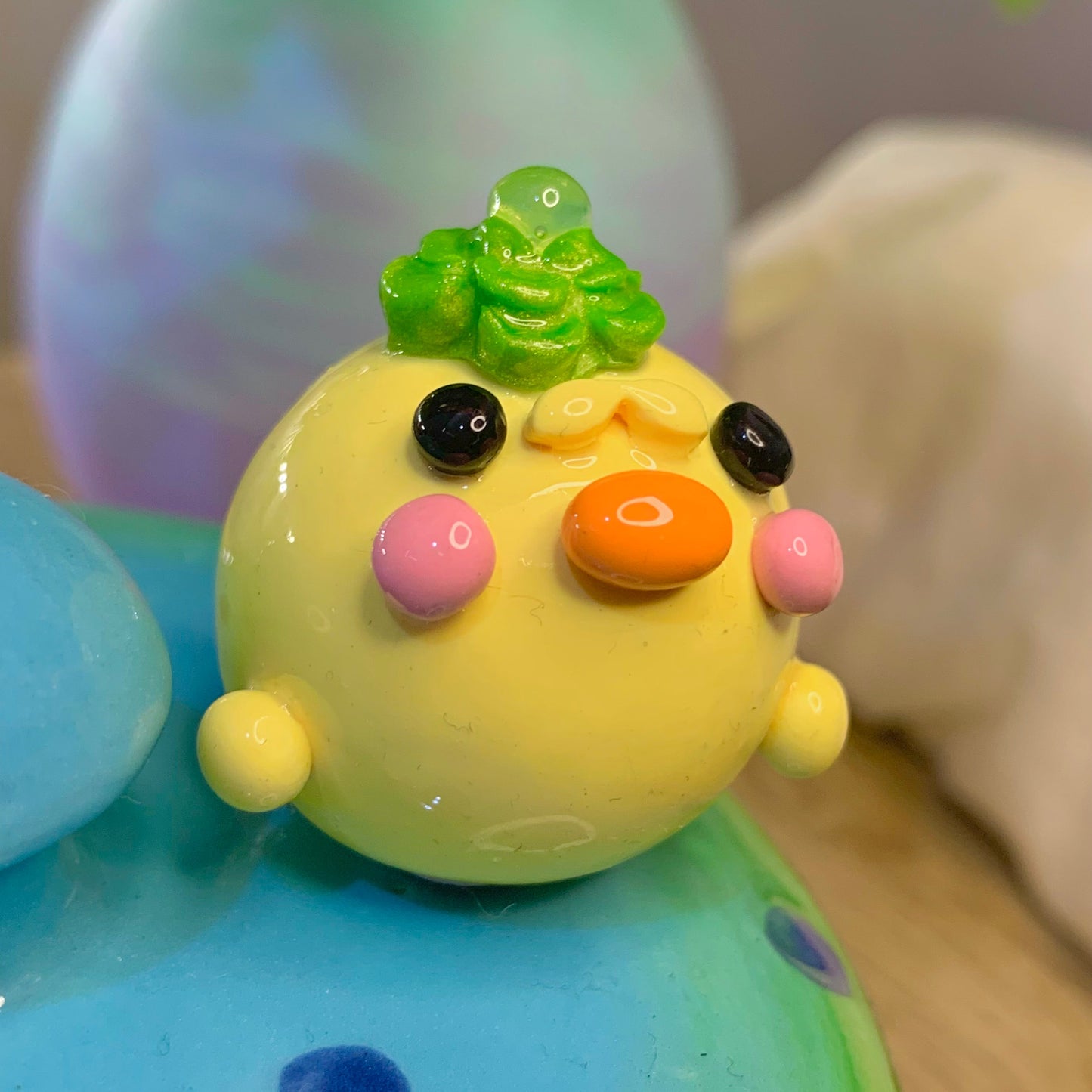 Colorful toy with a green top and various colored buttons on a blurred background