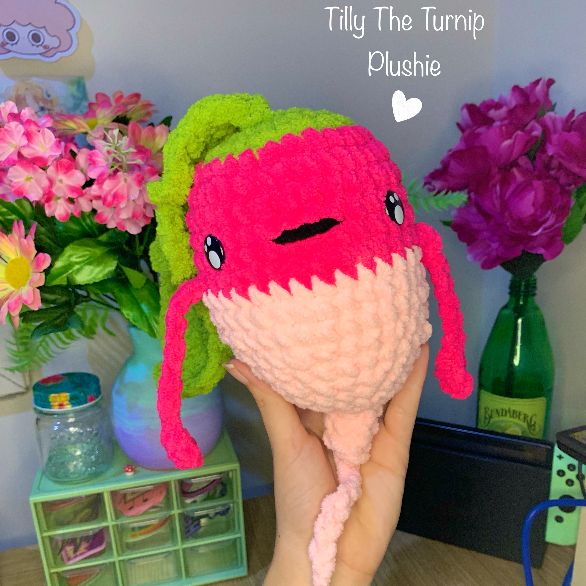 Plush toy shaped like a turnip held by a person, with flowers and a green container in the background.