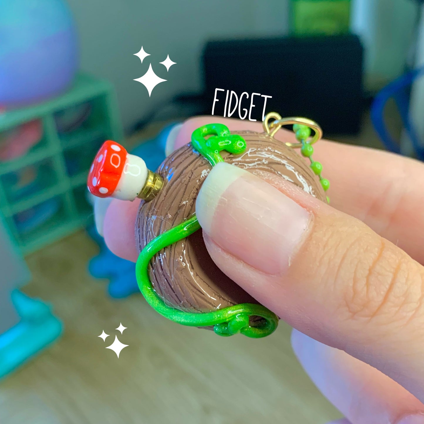 Fidget spinner held by a finger with a colorful design on a blurred background